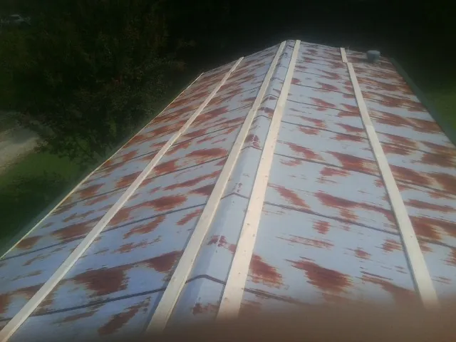 Rusted metal roof panels with new wood purlins before replacement — Storm Damage Roof Repair in Wynne by Roofing Brothers