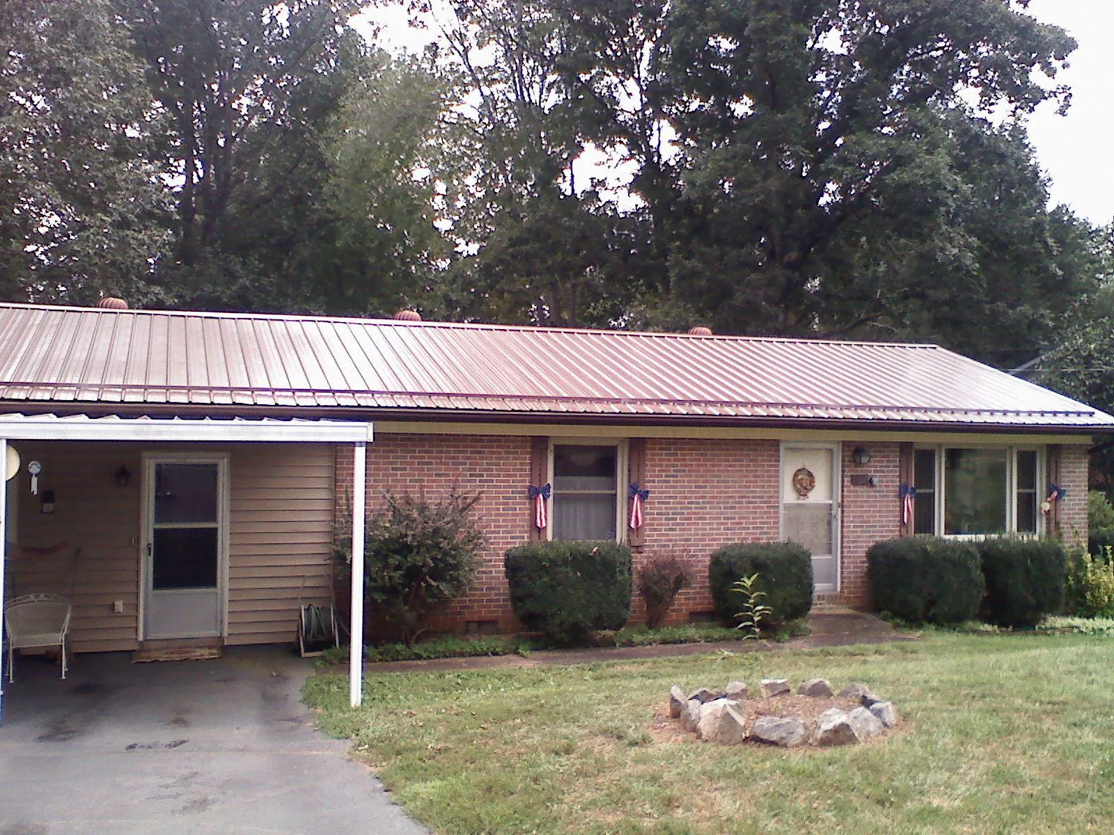 Bronze metal roof and carport on a brick ranch home — Roof Repair work by our crew in Wynne