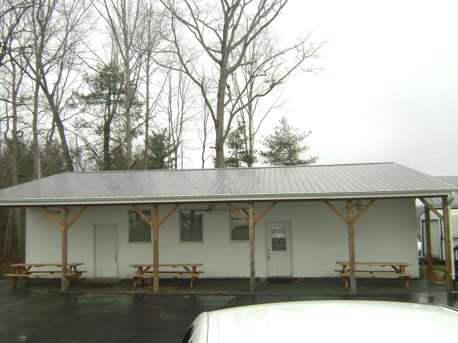 Gray metal roof over a block building with a timber post porch in Wynne